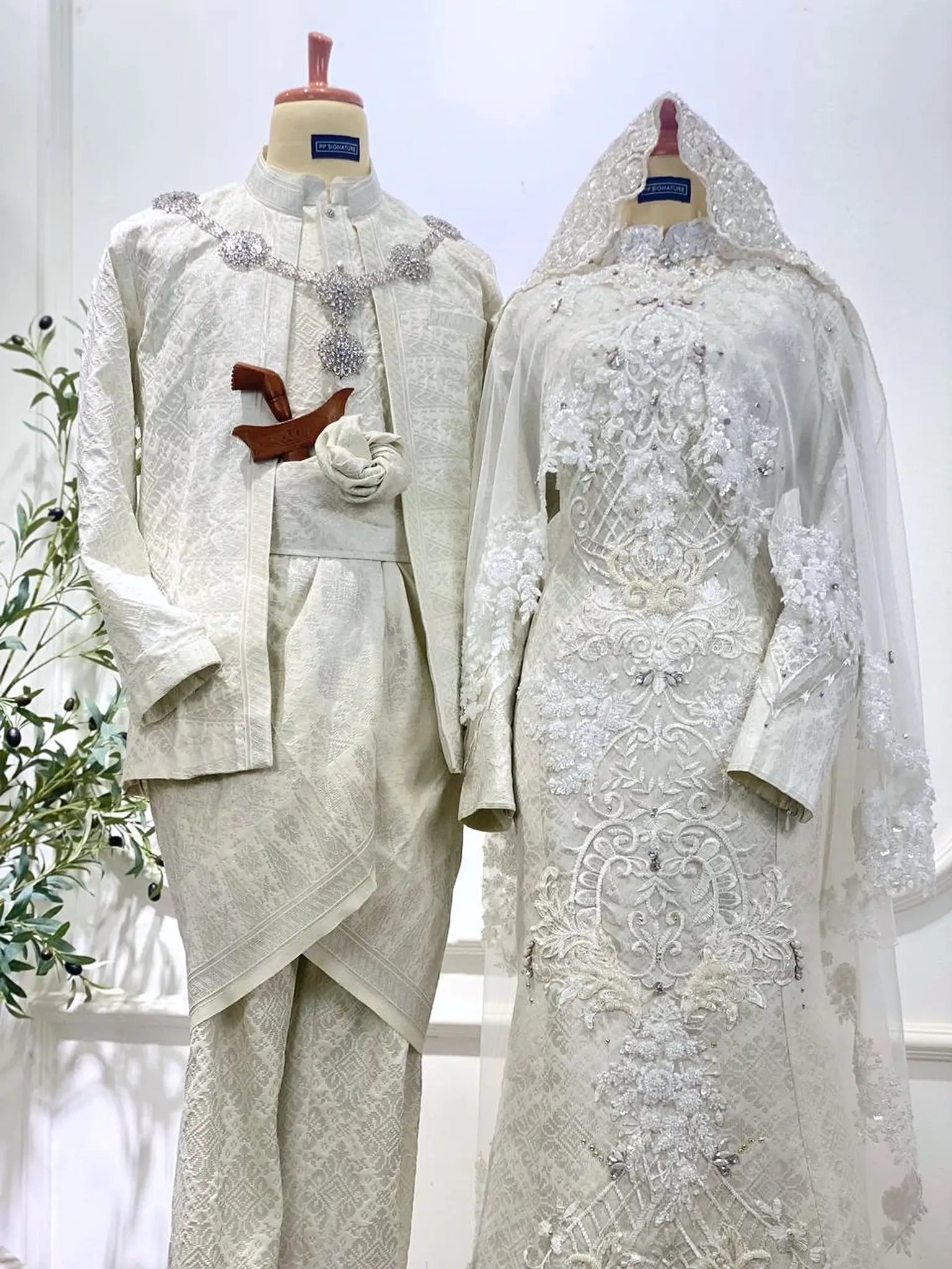 Close-up of Baju Pengantin couple in Off White songket from PP Signature Bridal-Bride with cape detail and groom in Kot Raihan suit styled for premium Sewa Baju Sanding