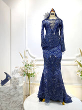 The bride’s two-piece dress design allows for graceful movement and a tailored fit, while the groom’s matching Kot Raihan two-piece set ties the couple together in timeless Malay tradition. 