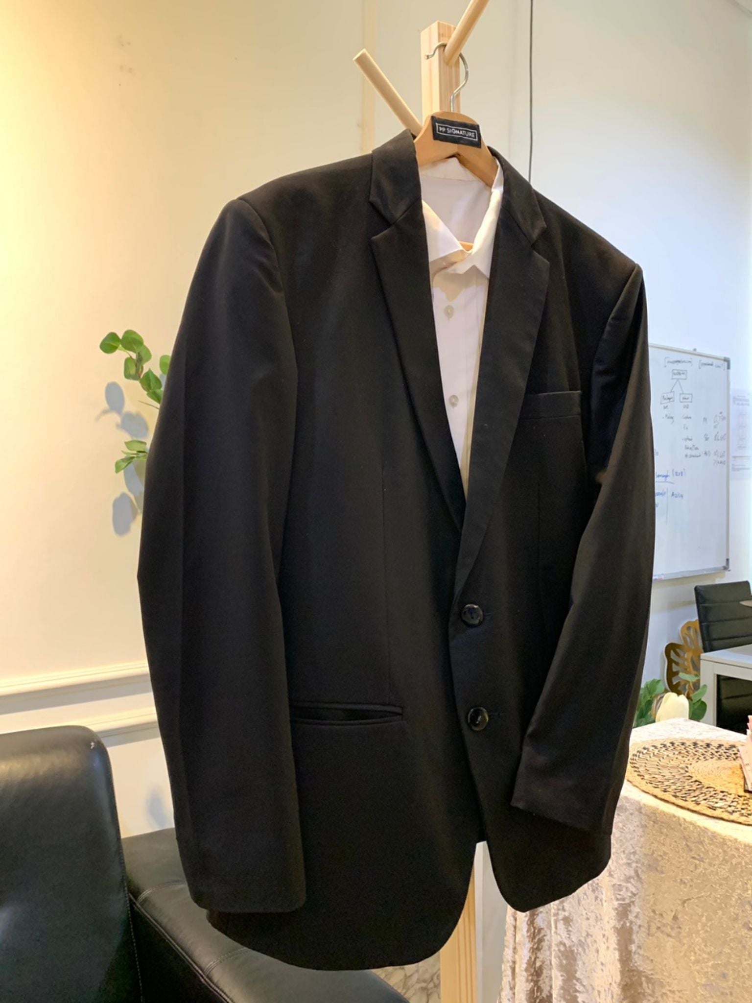 A close-up image of a black wedding suit with a notch lapel. The suit is made from high-quality wool fabric and is fully lined for a comfortable fit. It is the perfect choice for a formal occasion, such as a wedding or black tie gala.