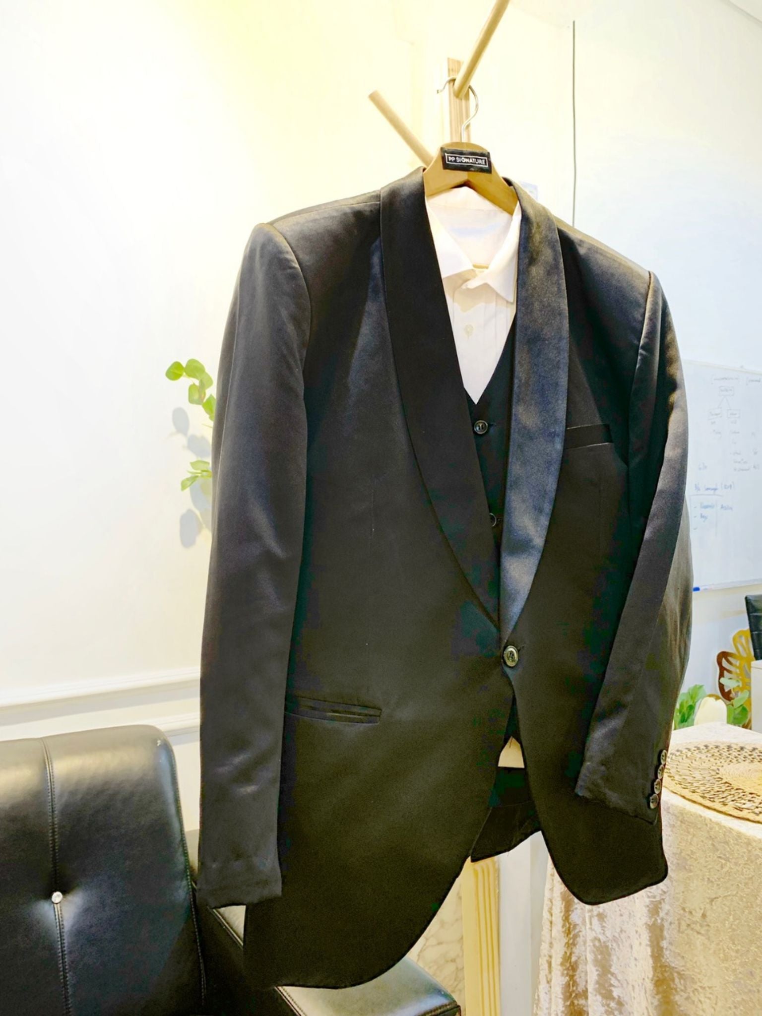 A close-up image of a black wedding suit with a shawl lapel. The suit is made from high-quality duchess fabric and is fully lined for a comfortable fit. It is the perfect choice for a formal occasion, such as a wedding or black tie gala.