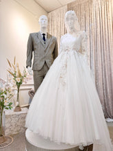 ELIZABETH  offers a mesmerizing ensemble for both bride and groom. Crafted from luxurious Duchess fabric with delicate lace detailing, the bride's attire features a stunning Ballgown design, while the groom can choose between a classic Suit or the intricate Kot Raihan Three-Piece ensemble. Available in sizes M to XL for both partners, this remarkable set is priced at MYR 850.00, down from RM1000.