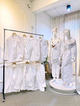 A photograph showcasing Nilam Sari's Baju Pengantin Songket in White with Silver, a blend of Thai-inspired bridal attire. The image captures the bride's ensemble, featuring a graceful Thai Dress design crafted from luxurious Songket 2D material, and the groom's attire, adorned with the intricate Kot Raihan 2pcs