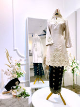 Embrace elegance on your special day with the SURIRAM Malay wedding dress rental package for bride & groom. This stunning ensemble features a light brown champagne Songket tabur Baju Kurung Moden for the bride and a classic black Baju Melayu teluk belanga for the groom. 