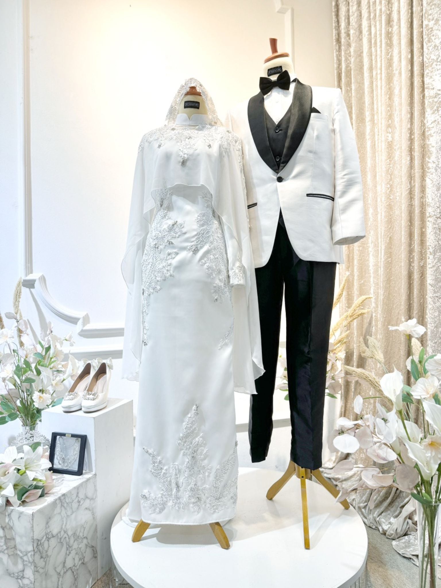 Introducing WARDAH's exquisite Baju Pengantin Off White Double Face Dress with Detachable Cape, priced at MYR 899.00. Tailored for the bride in sizes XS to M and the groom in sizes S to 2XL, both in a charming off-white hue. The bride's ensemble features a stylish dress with a detachable cape, while the groom dons the signature suit design. Crafted from premium double face material, this set, originally priced at RM1150, promises timeless elegance for your special day.