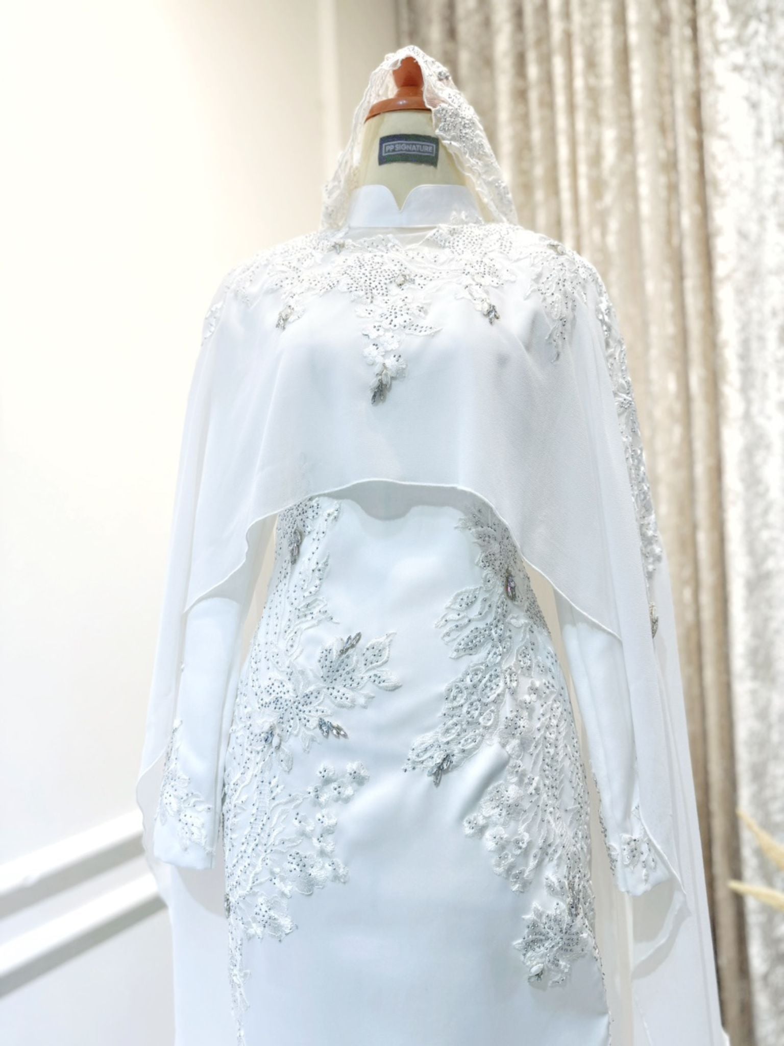 Introducing WARDAH's exquisite Baju Pengantin Off White Double Face Dress with Detachable Cape, priced at MYR 899.00. Tailored for the bride in sizes XS to M and the groom in sizes S to 2XL, both in a charming off-white hue. The bride's ensemble features a stylish dress with a detachable cape, while the groom dons the signature suit design. Crafted from premium double face material, this set, originally priced at RM1150, promises timeless elegance for your special day.