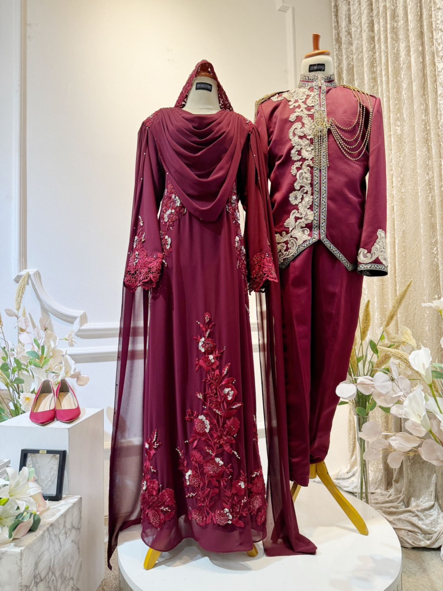WARDINA offers a captivating Baju Pengantin ensemble in Maroon Burgundy, tailored for your wedding reception (Baju Sanding). The bride's attire features a graceful loose dress with an elegant shoulder cape, while grooms can choose between the classic Prince Suit or the traditional Kot Raihan 3-piece set. Crafted from luxurious chiffon material, this ensemble epitomizes sophistication and style, ensuring a memorable presence for both bride and groom on their special day.