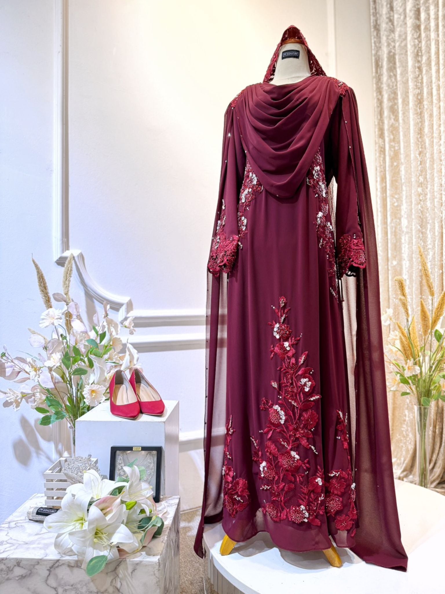 WARDINA offers a captivating Baju Pengantin ensemble in Maroon Burgundy, tailored for your wedding reception (Baju Sanding). The bride's attire features a graceful loose dress with an elegant shoulder cape, while grooms can choose between the classic Prince Suit or the traditional Kot Raihan 3-piece set. Crafted from luxurious chiffon material, this ensemble epitomizes sophistication and style, ensuring a memorable presence for both bride and groom on their special day.
