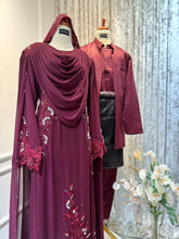 WARDINA's Maroon Burgundy bridal ensemble, perfect for Malay weddings in Malaysia. Featuring a loose dress & shoulder cape for the bride, and Prince Suit or Kot Raihan 3pcs for the groom. Crafted from luxurious chiffon, ideal for traditional wedding receptions.