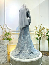 Elegant light grey songket dress with dark grey details for Malay wedding reception.