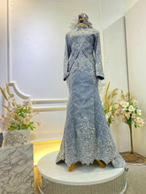 Graceful Malay wedding dress in songket fabric with intricate detailing.