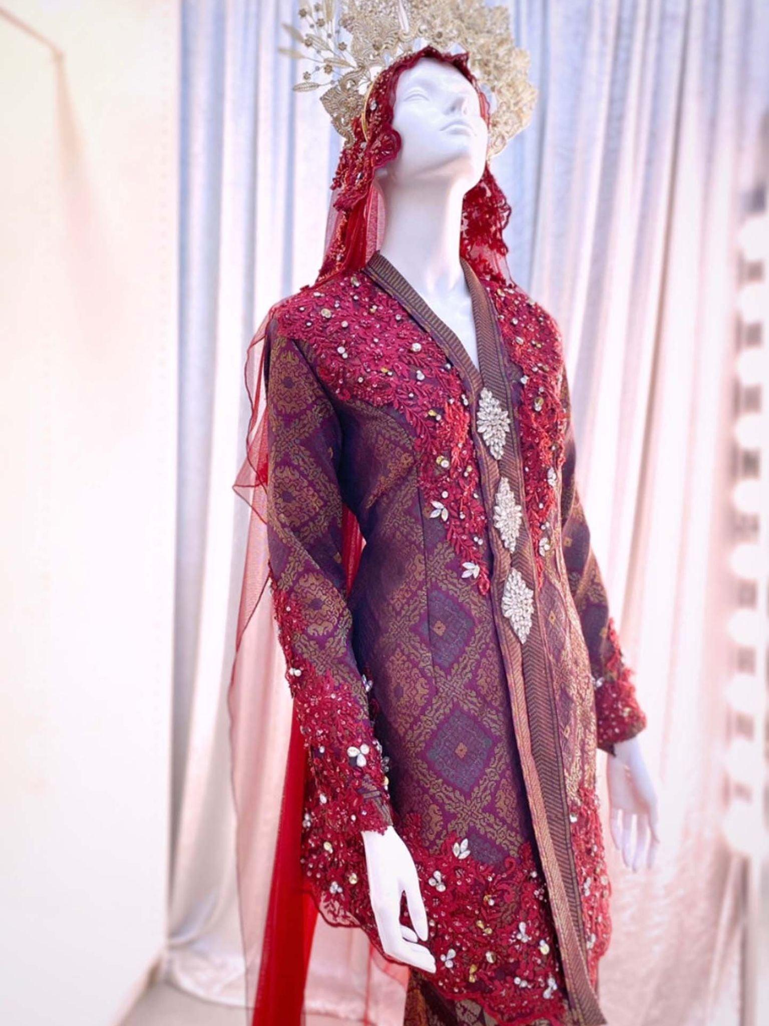 Sepasang Baju Pengantin Kebaya Songket lengkap aksesori oleh Butik Pengantin PP Signature dipakai patung Lelaki dan perempuan berwarna merah maroon untuk disewa-A pair of Kebaya songket wedding dresses complete with accessories by PP Signature Bridal Boutique worn by male and female statues in maroon for rent