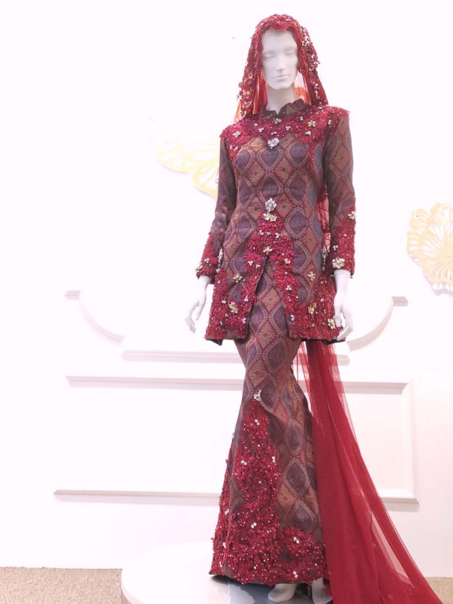 Sepasang Baju Pengantin Baju Kurung Moden Songket lengkap aksesori oleh Butik Pengantin PP Signature dipakai patung Lelaki dan perempuan berwarna merah maroon untuk disewa-A pair of Modern Kurung Songket Dress wedding dresses complete with accessories by PP Signature Bridal Boutique worn by male and female statues in maroon for rent