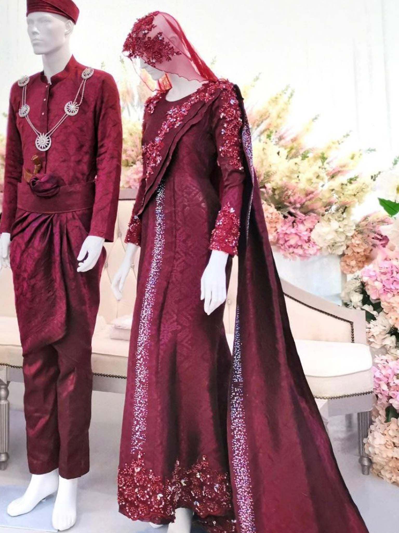 Sepasang Baju Pengantin Dress Sari Songket lengkap aksesori oleh Butik Pengantin PP Signature dipakai patung Lelaki dan perempuan berwarna merah maroon untuk disewa-A pair of Dress Sari Songket wedding dresses complete with accessories by PP Signature Bridal Boutique worn by male and female statues in maroon for rent