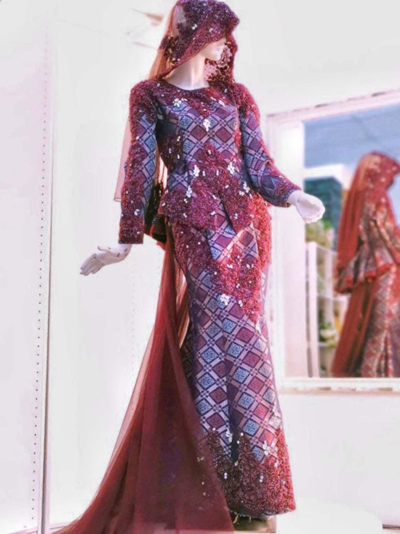 Sepasang Baju Pengantin Dress with trail songket dan kot raihan lengkap aksesori oleh Butik Pengantin PP Signature dipakai patung Lelaki dan perempuan berwarna merah maroon untuk disewa-A pair of Songket Dress With Trail wedding dresses as well as Raihan Coat complete with accessories by PP Signature Bridal Boutique worn by male and female statues in maroon for rent