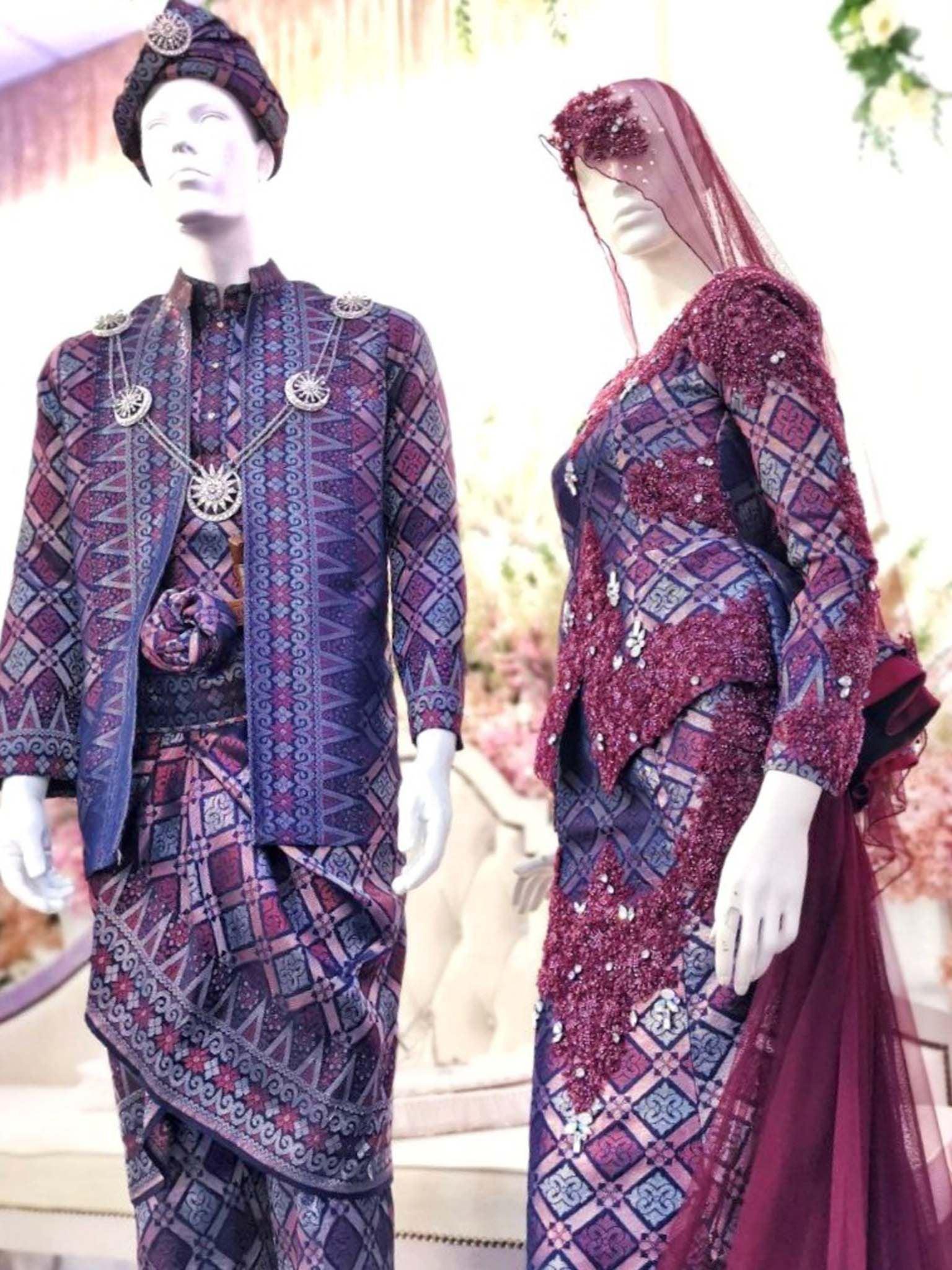 Sepasang Baju Pengantin Dress with trail songket dan kot raihan lengkap aksesori oleh Butik Pengantin PP Signature dipakai patung Lelaki dan perempuan berwarna merah maroon untuk disewa-A pair of Songket Dress With Trail wedding dresses as well as Raihan Coat complete with accessories by PP Signature Bridal Boutique worn by male and female statues in maroon for rent