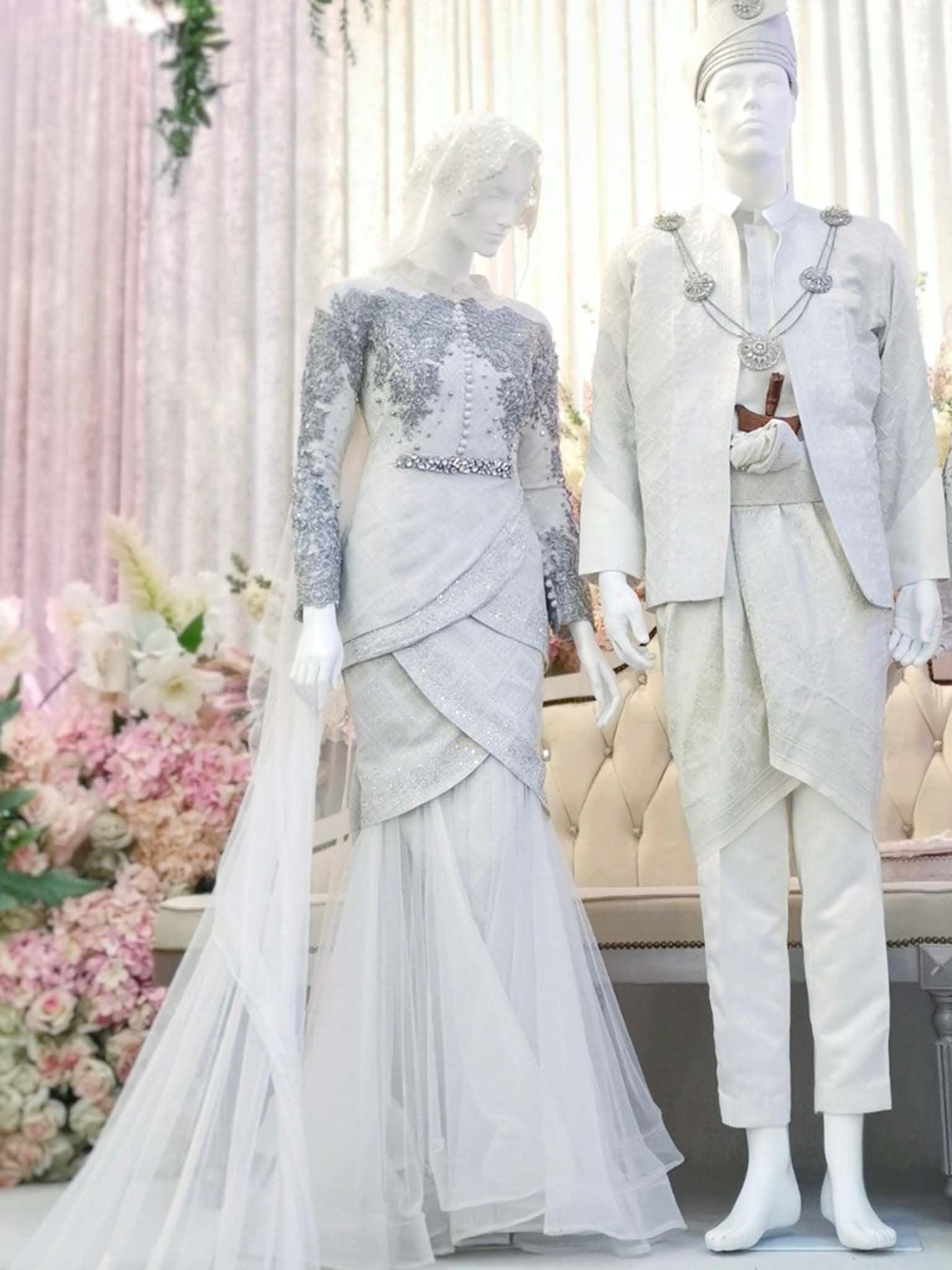 Sepasang baju pengantin songket, Two-Piece Tulip Dress berwarna putih dan perak lengkap aksesori buatan Butik Pengantin PP Signature-a pair of songket wedding dresses, Two-Piece Tulip Dress in off white and silver complete with accessories by PP Signature Bridal Boutique